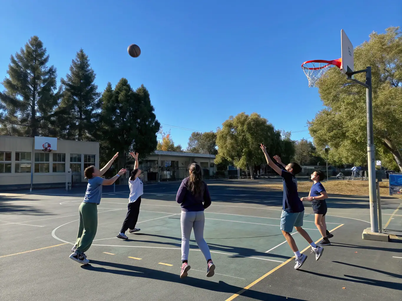 A dynamic image of children playing basketball outdoors, emphasizing the fun and inclusive nature of VOLC'UP's youth sports programs.